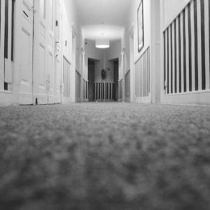 pexels-photo-1253800-1253800 Low angle view of an empty hotel corridor with striped walls and carpet in monochrome.